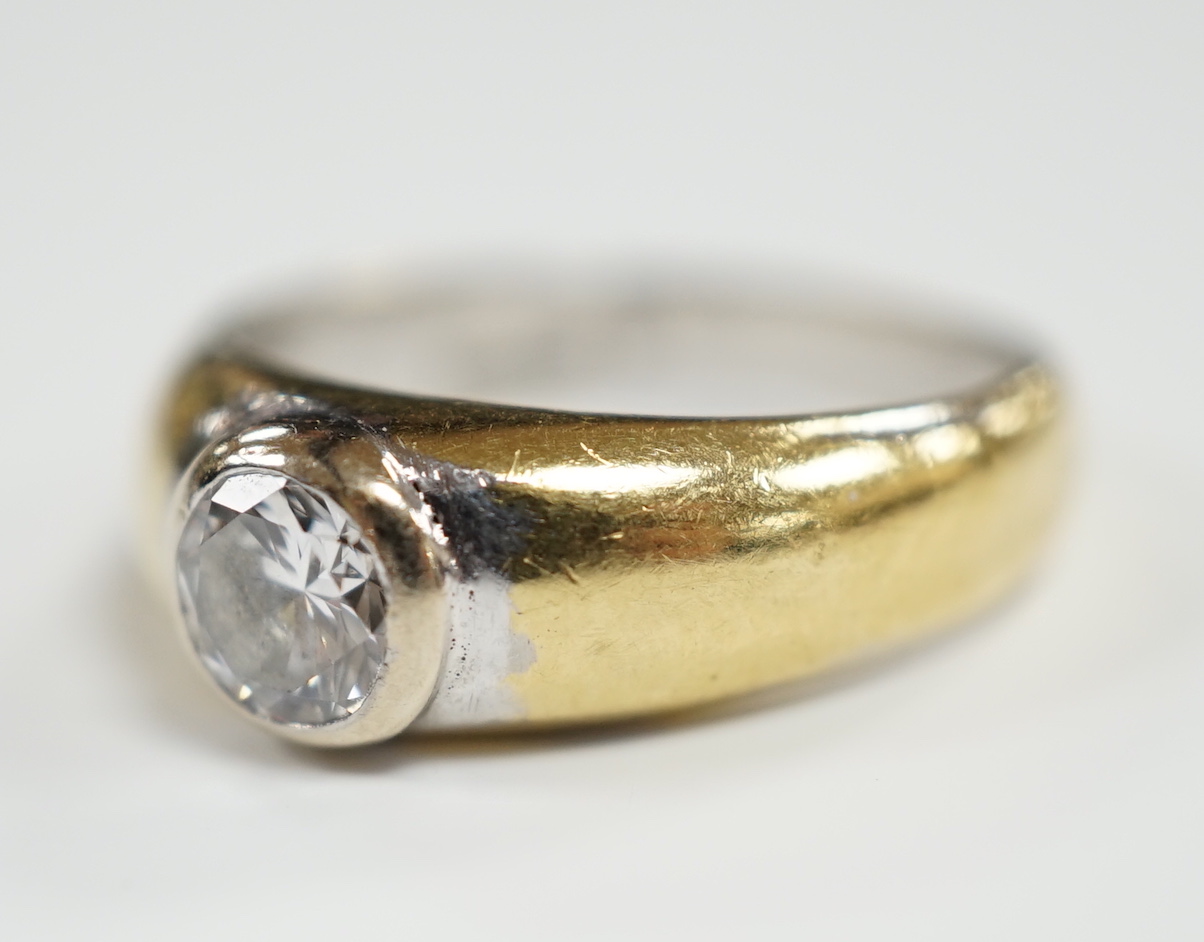 A modern 18ct gold and collet set solitaire diamond ring, size N, gross weight 7.6 grams, the stone weighing approx. 0.55ct.